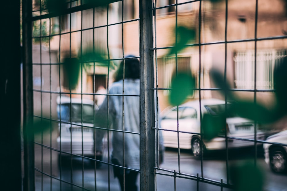 man in white dress shirt standing near green car during daytime