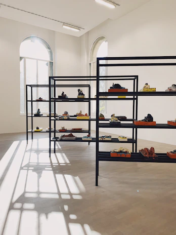 Bright, sunlit atelier space with shelves displaying finished 3D artworks.