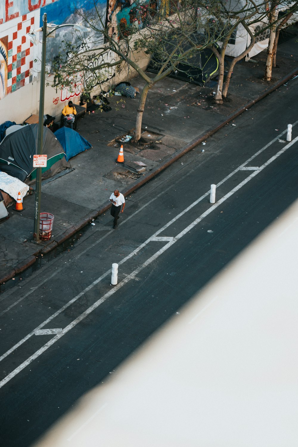 woman in white shirt walking on sidewalk during daytime