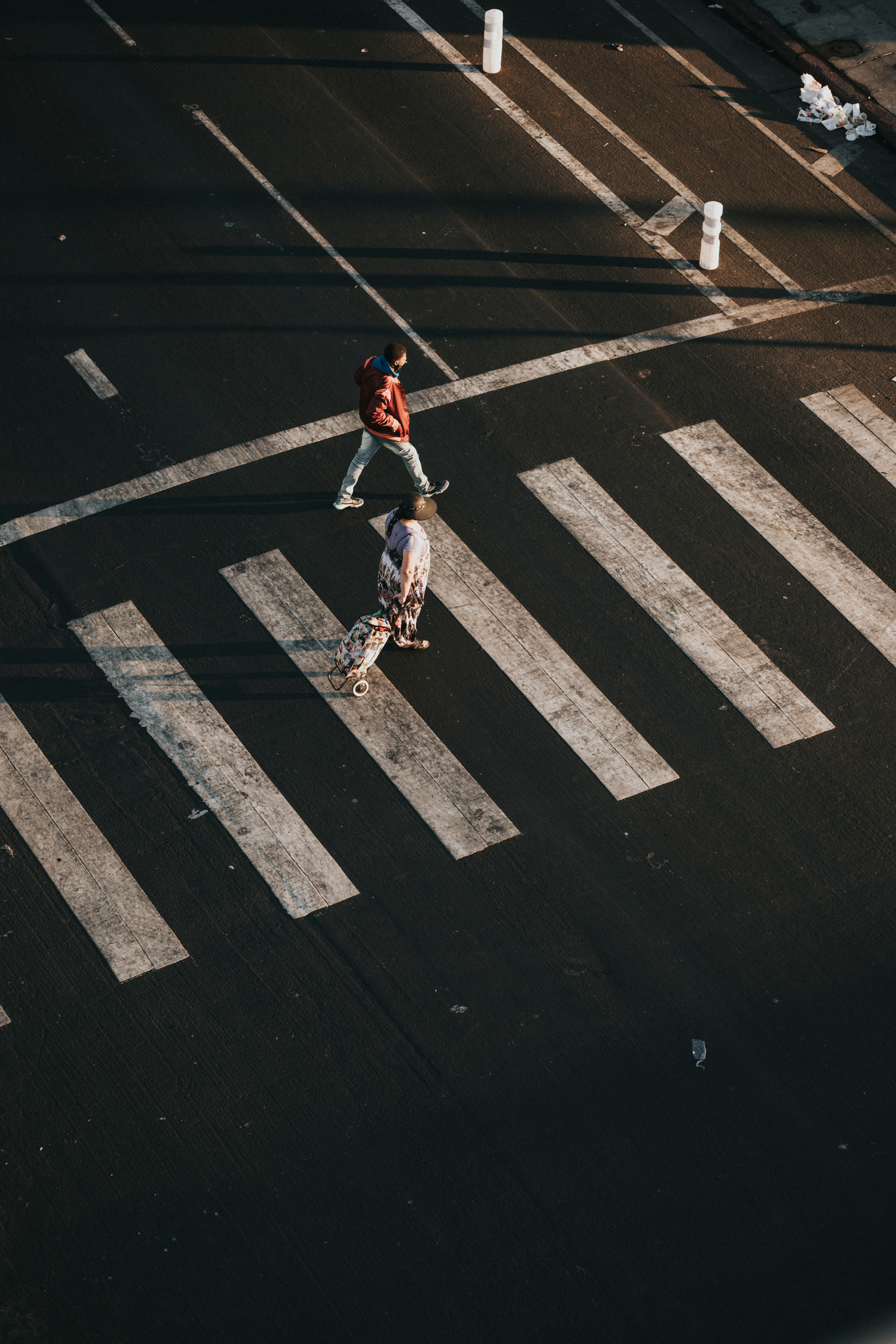 man in black t-shirt and white shorts riding skateboard on black asphalt road during daytime