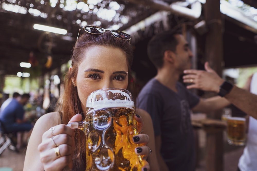 Frau in schwarzem Langarmhemd mit Trinkglas