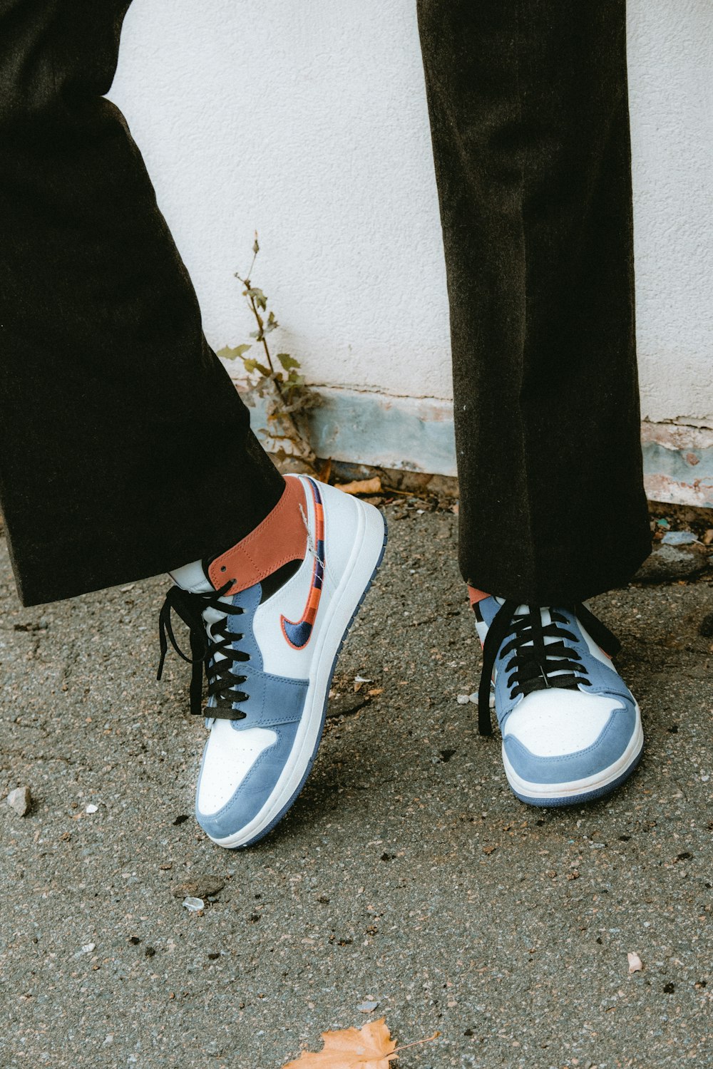 person wearing black and white adidas sneakers