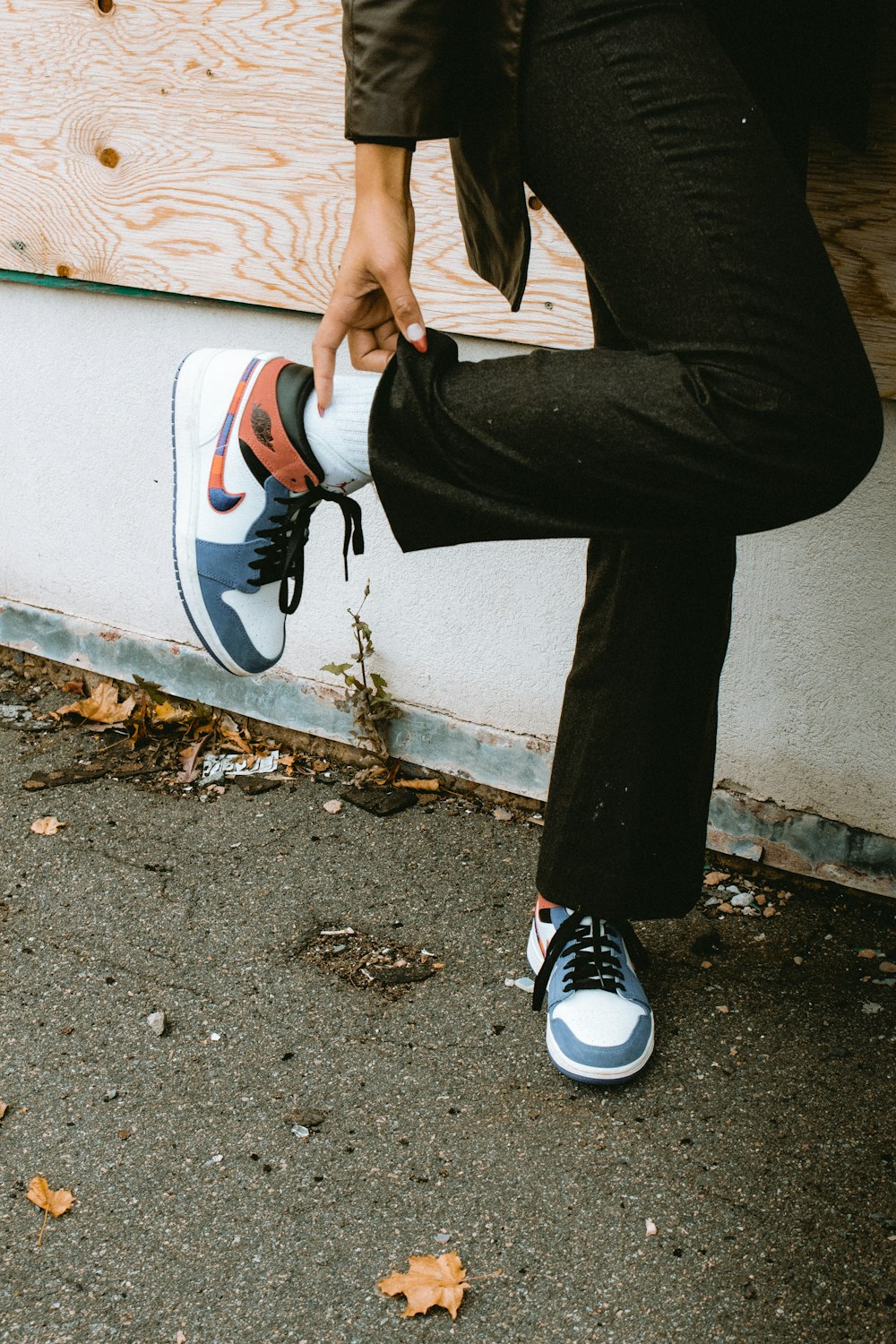 person in black pants and white nike sneakers