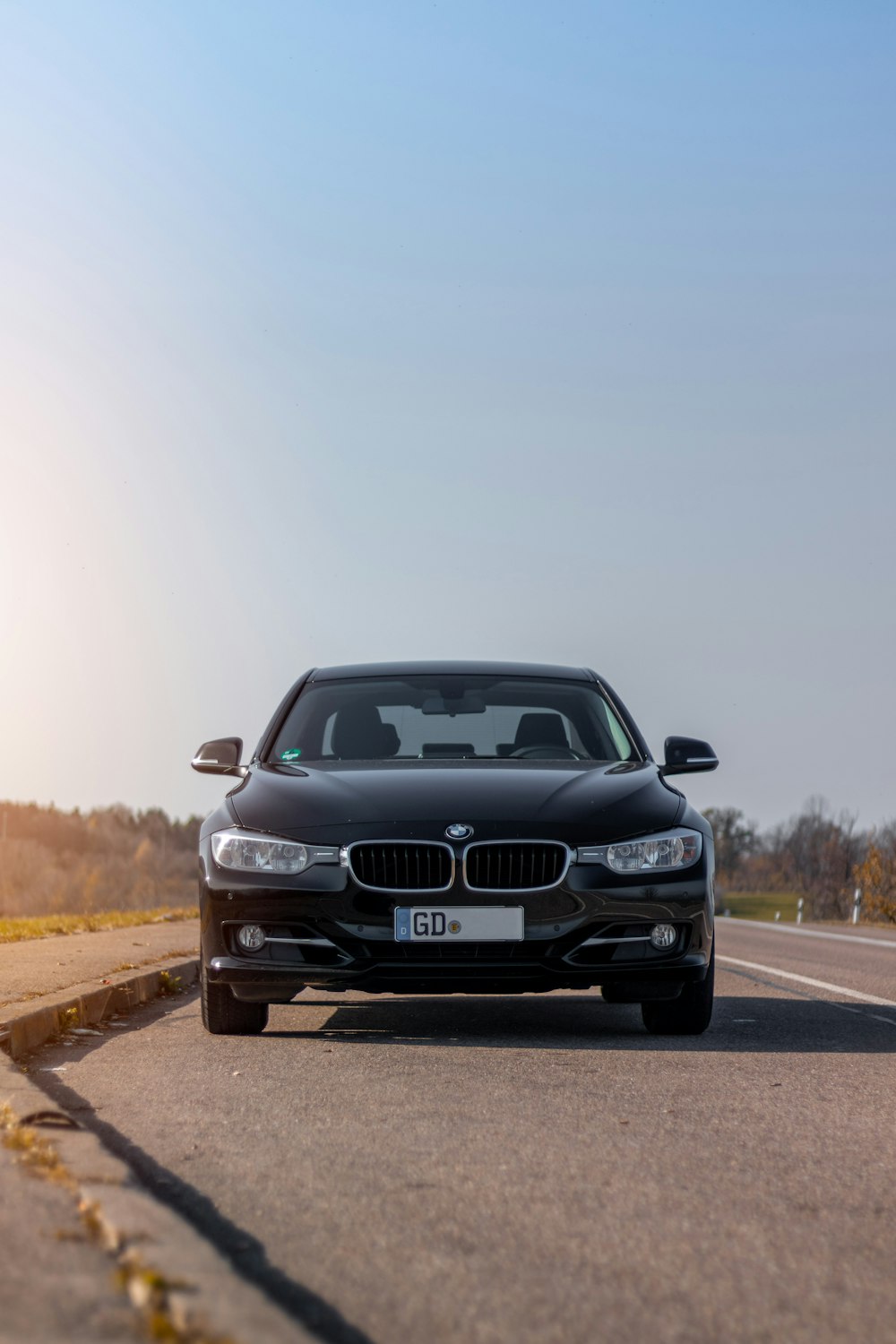 昼間の道路上の黒いBMW車