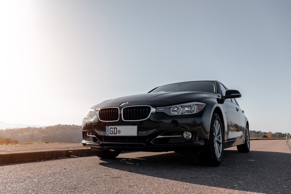 BMW M 3 noire sur un chemin de terre brun