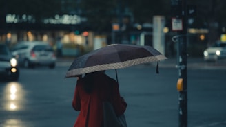 person in red coat holding umbrella