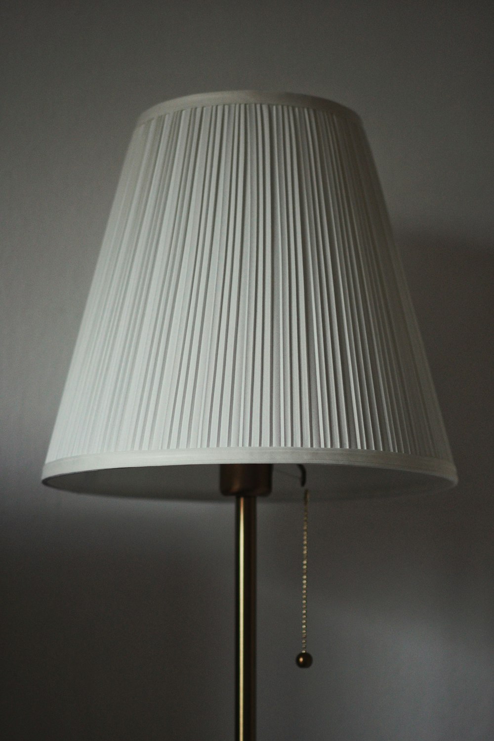 white table lamp turned on near white wall