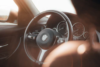 Bright and modern BMW interior after professional detailing with sunlight highlighting the dashboard.