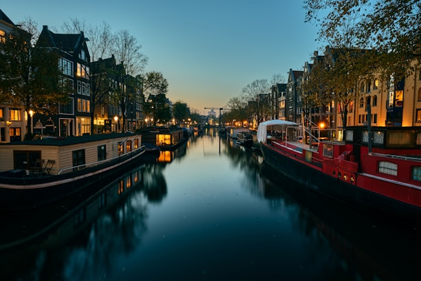 A cozy, illuminated houseboat at dusk reflecting beautifully over the river.