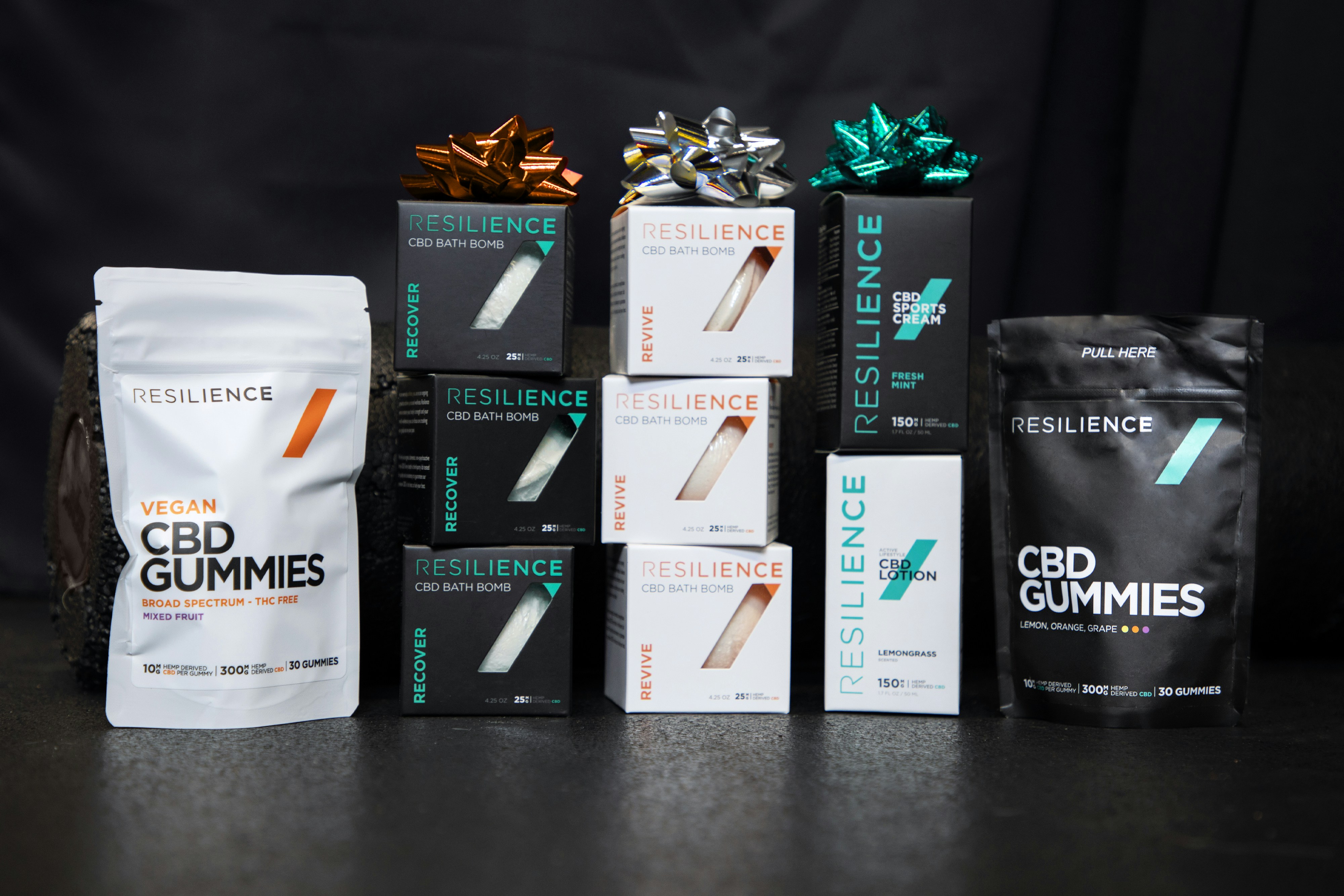 Resilience CBD products with black background and fitness equipment.