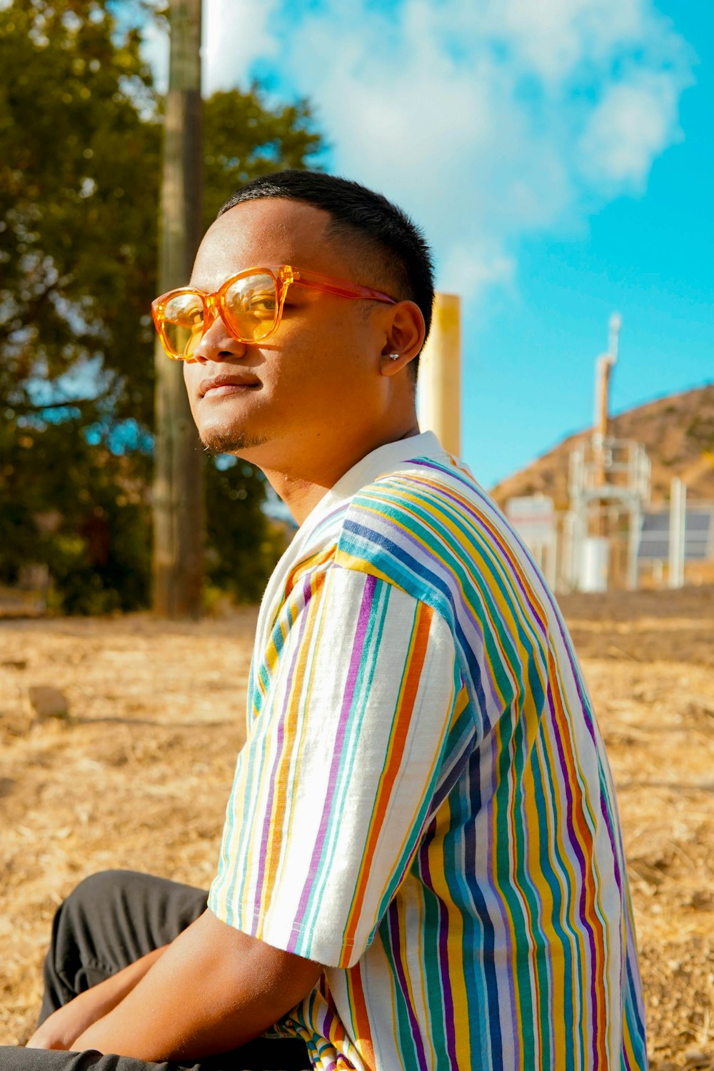 man in white blue and red striped shirt wearing sunglasses