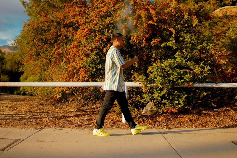 A person walking outdoors in athletic shoes on a paved path — the everyday gesture that foot care comes down to
