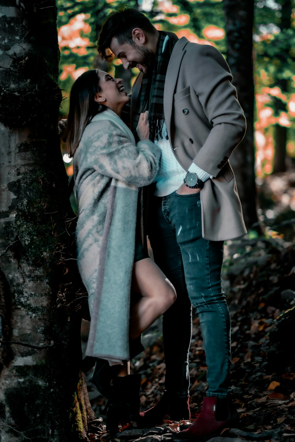 uomo e donna in piedi accanto all'albero