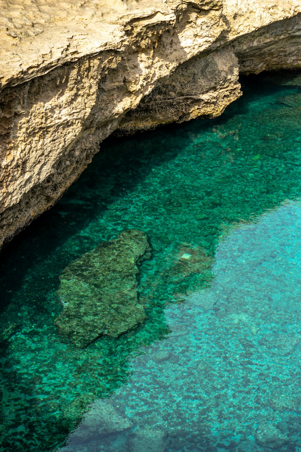 brown rock formation beside blue sea during daytime