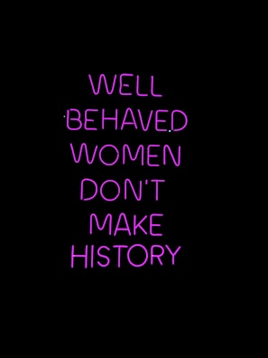 Neon pink text on a black background conveying a powerful message about the impact of behavior on making history.