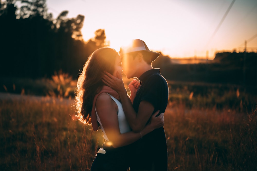 man and woman kissing during sunset