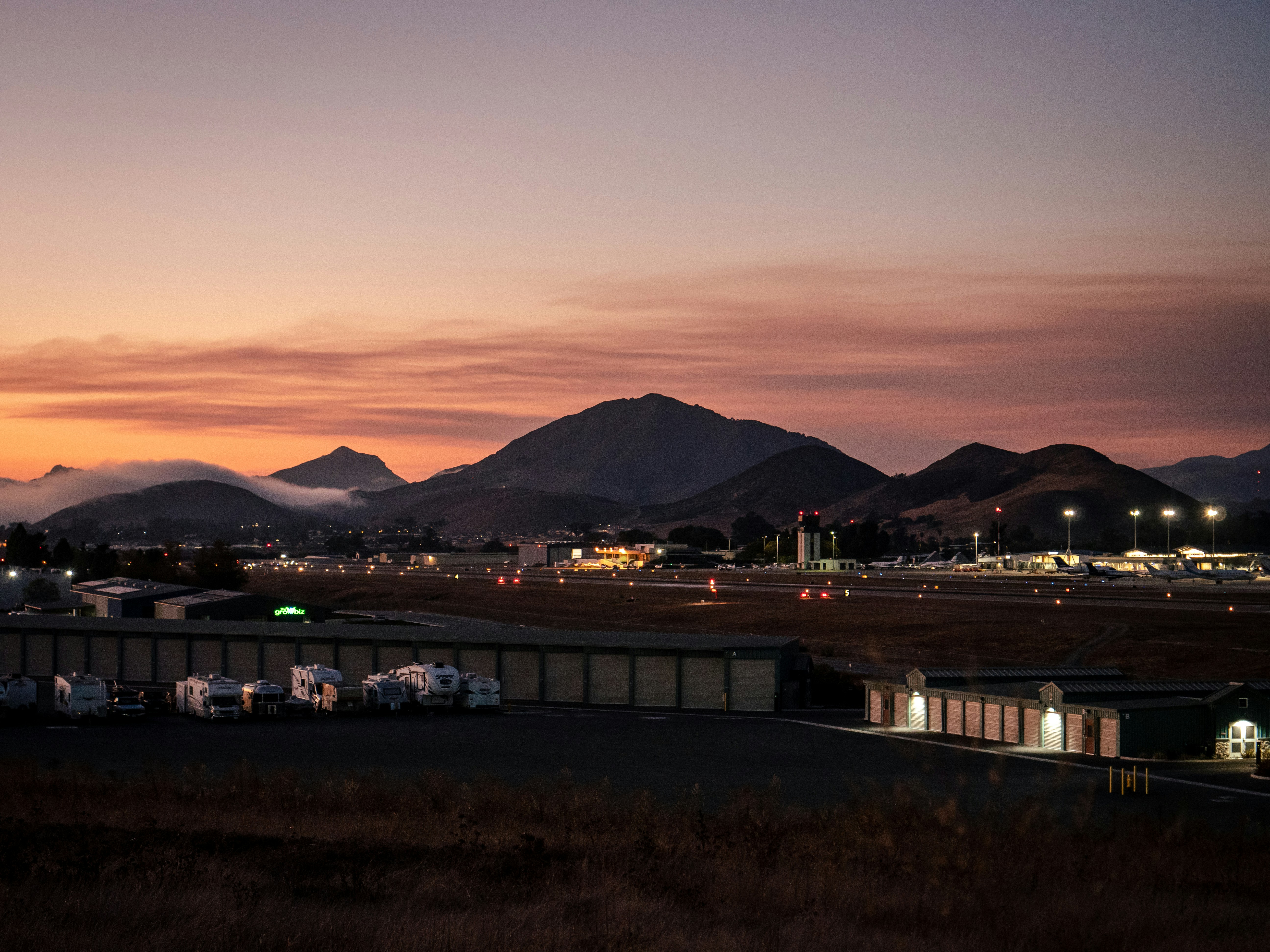 white and brown building near mountain during sunset