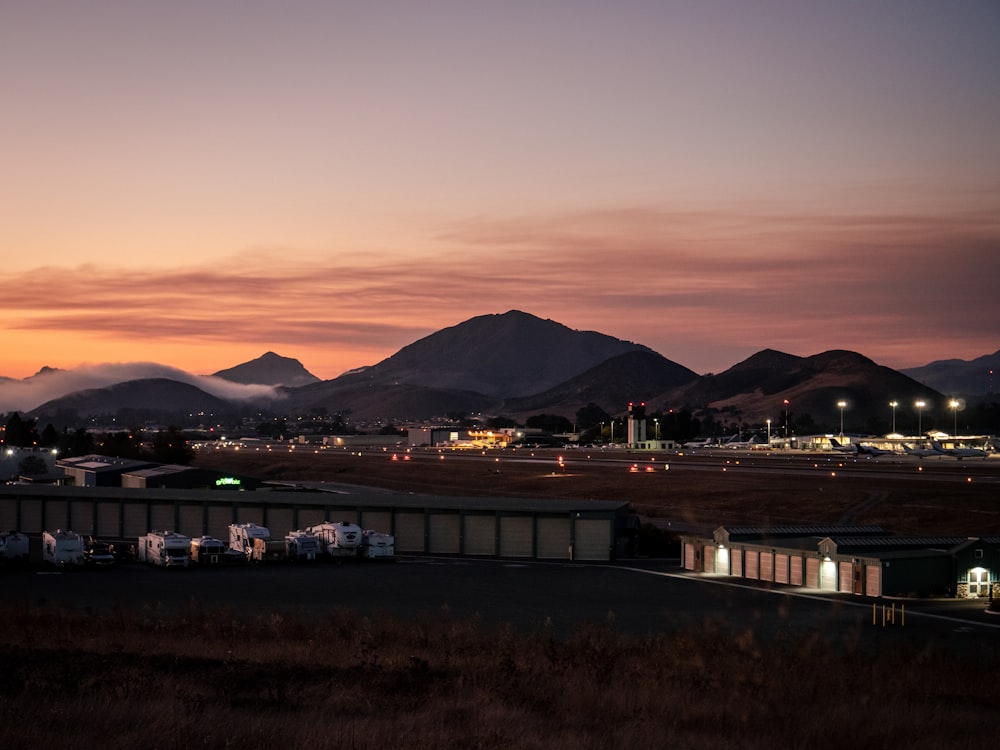 Weißes und braunes Gebäude in der Nähe des Berges bei Sonnenuntergang