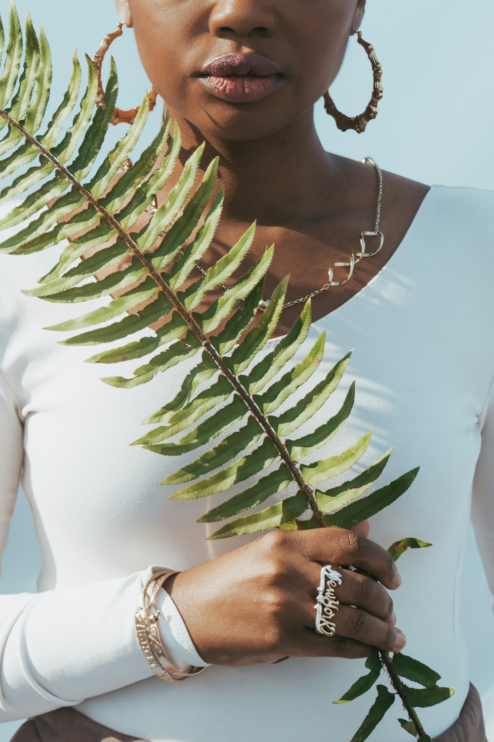 woman in white shirt holding green plant