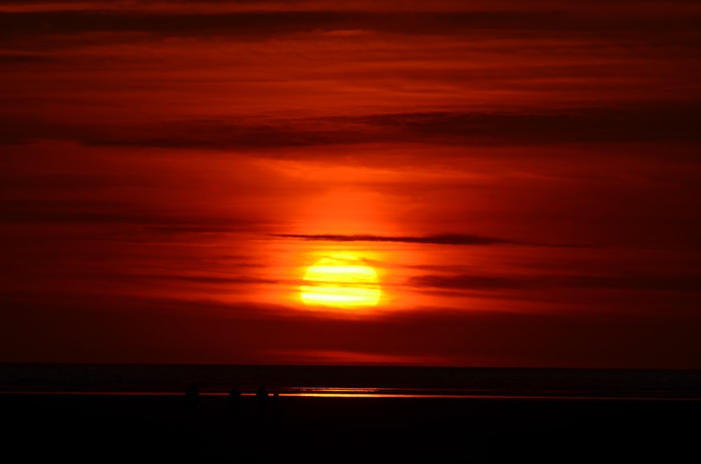 silhouette of person standing on sea dock during sunset