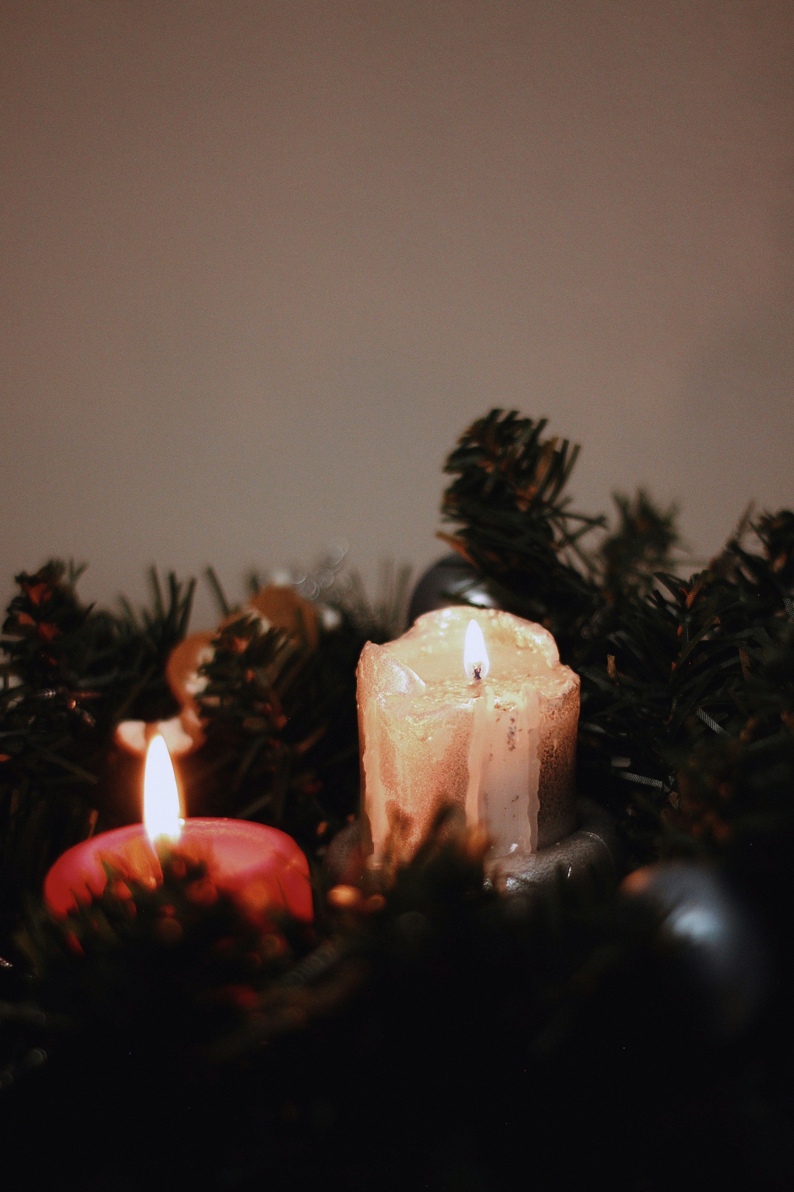 white pillar candle on green christmas tree