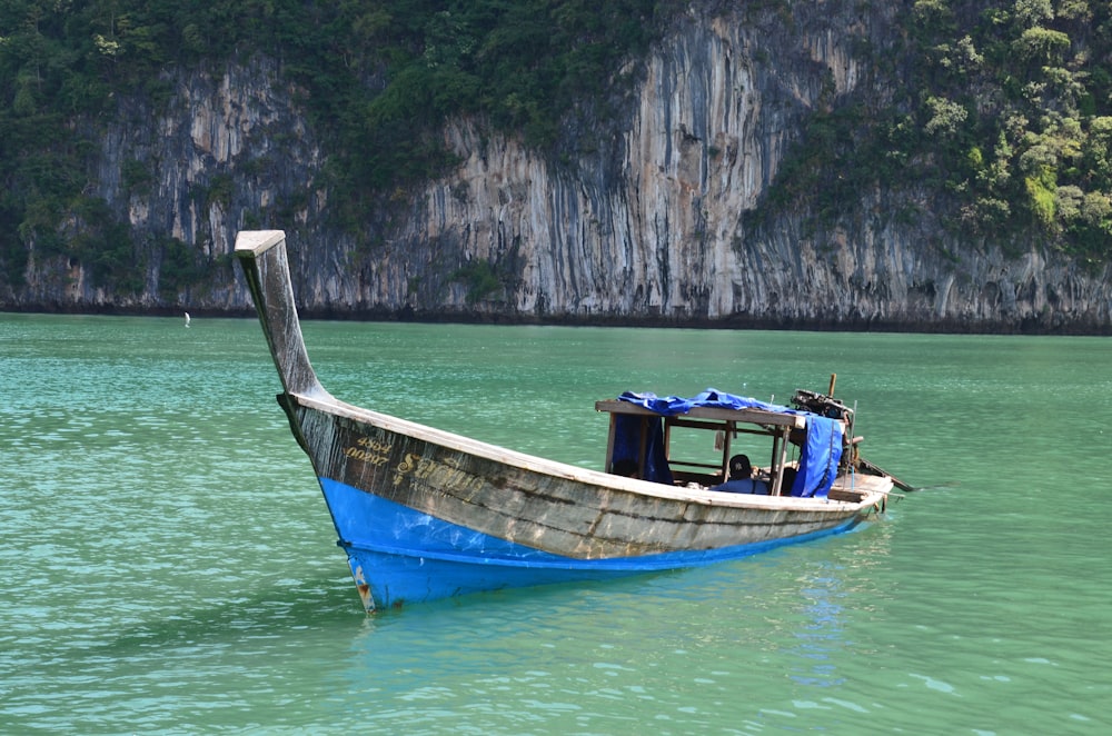 blue and brown boat on body of water during daytime