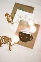 A cozy holiday setting with a cup of hot cocoa beside a shimmering foil-stamped greeting card.