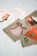 A set of holiday-themed cards featuring hand-painted designs of a bauble, green mittens, and a gingerbread man cookie. The cards are placed on a white surface with delicate fairy lights adding a warm glow, enhancing the festive atmosphere.
