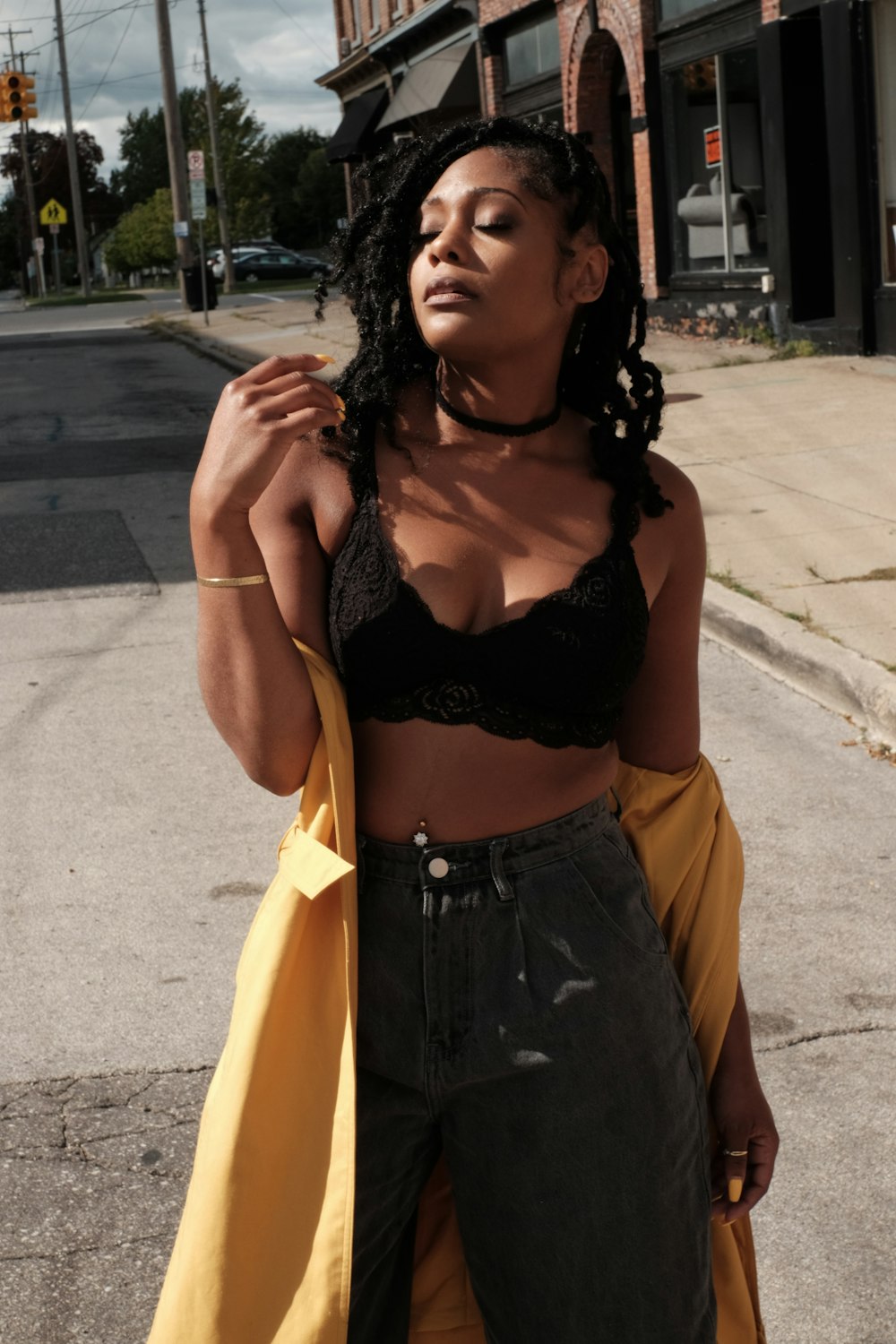 woman in black brassiere and yellow skirt standing on road during daytime