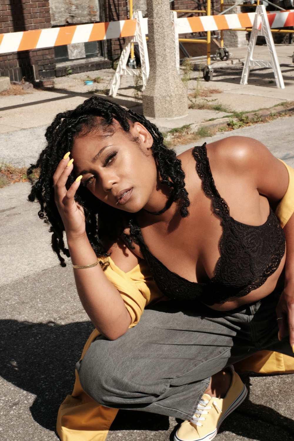 woman in black brassiere and yellow shirt sitting on concrete bench