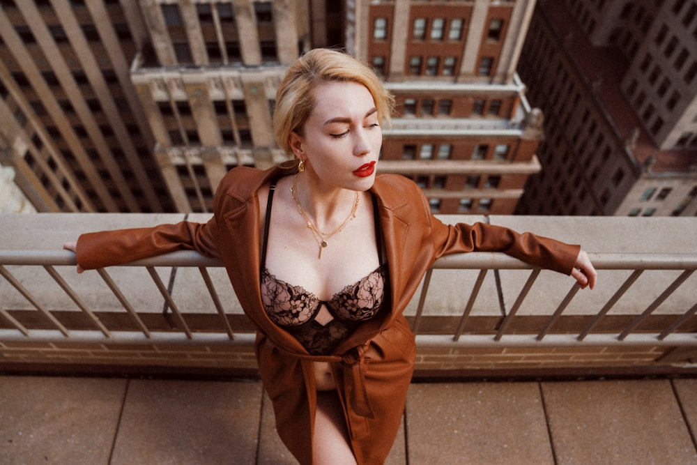 woman in orange blazer standing on brown concrete stairs