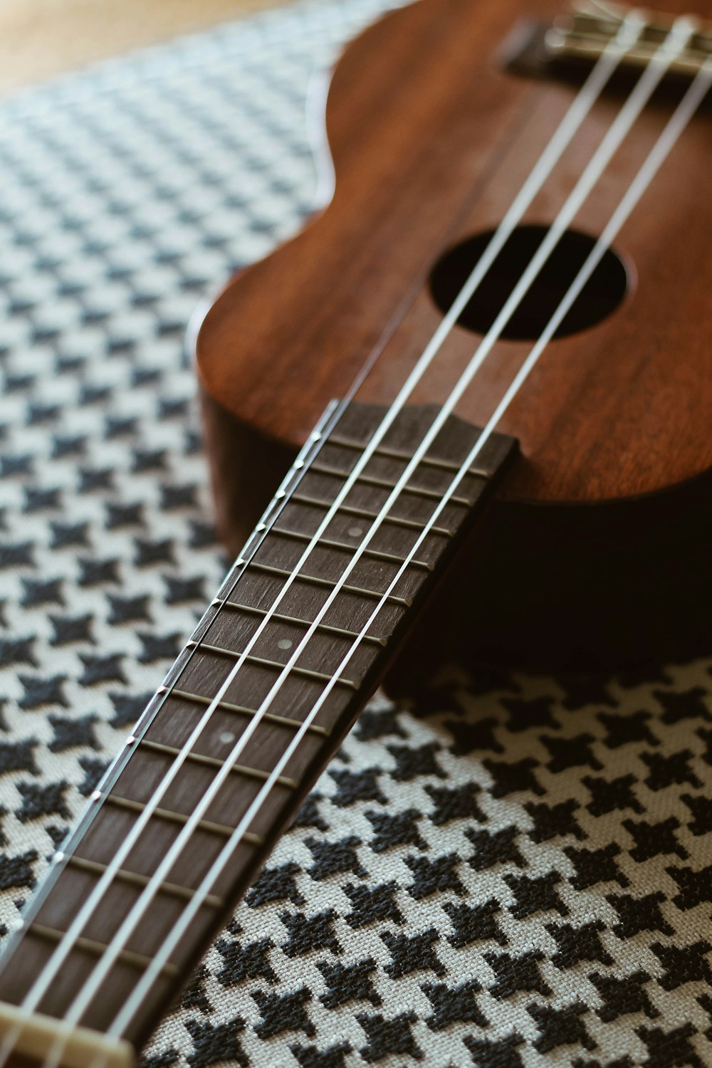 brown acoustic guitar on white and black textile