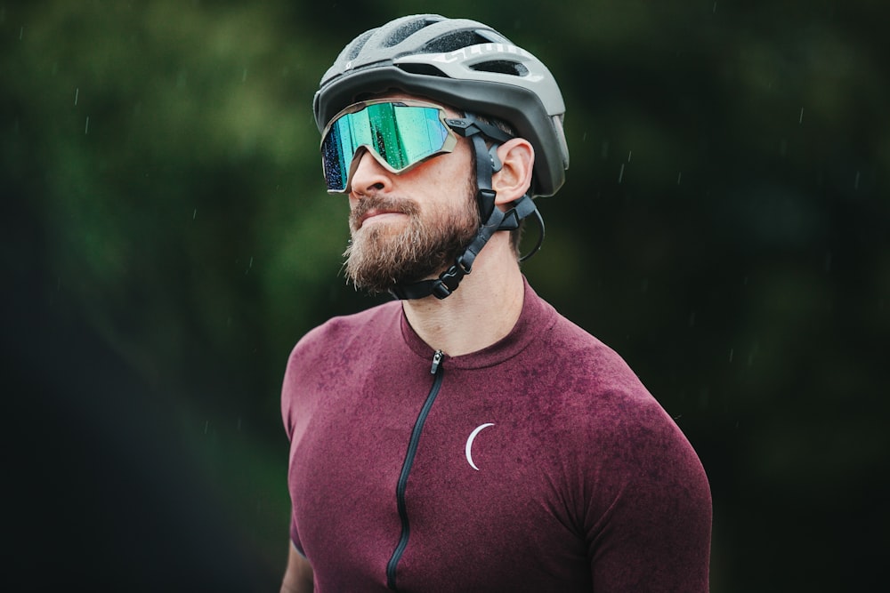 Mann in rotem Nike-Rundhalsshirt mit schwarz-weißem Helm und schwarzer Sonnenbrille