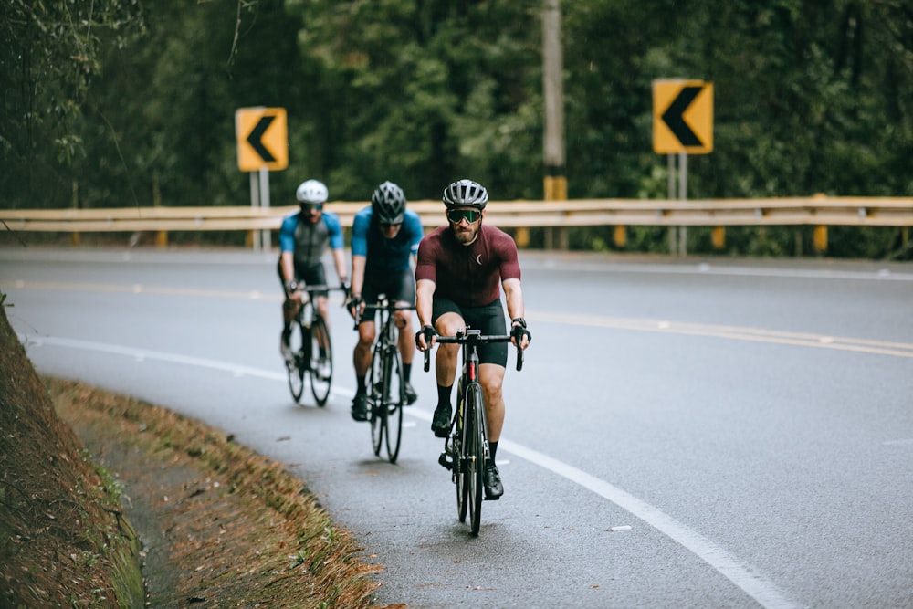 hombres que andan en bicicleta por la carretera durante el día