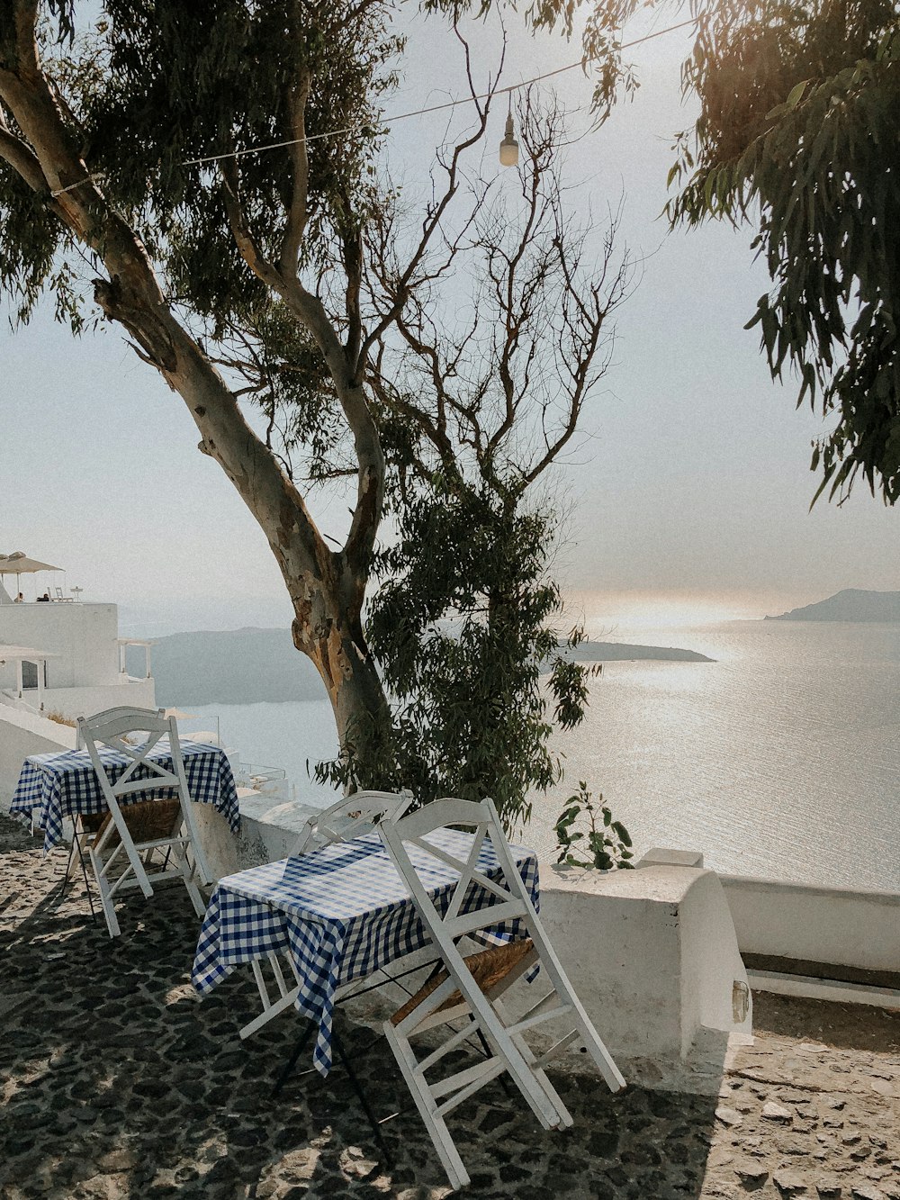 white and blue table and chairs near body of water during daytime