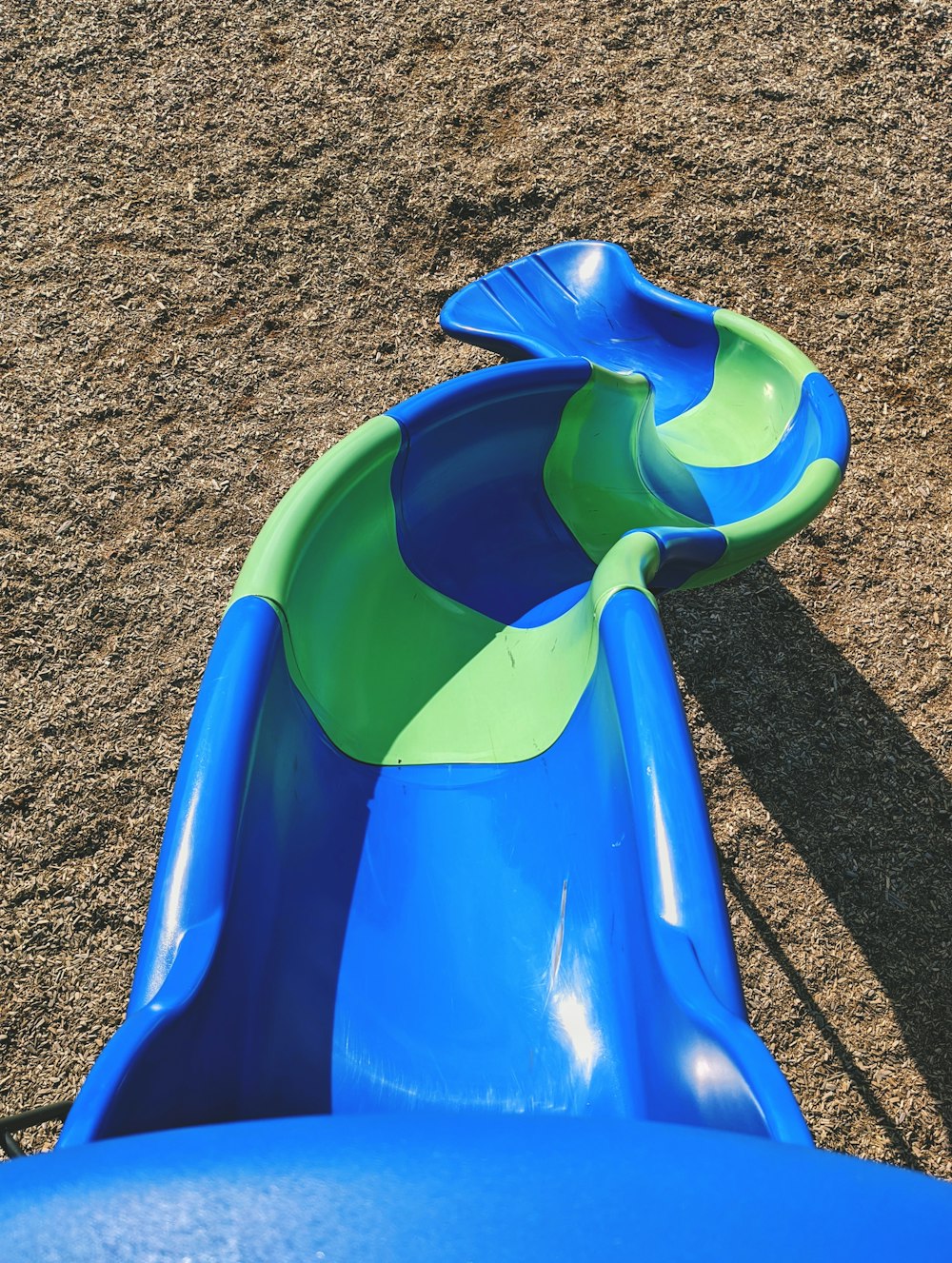 blue plastic slide on brown sand