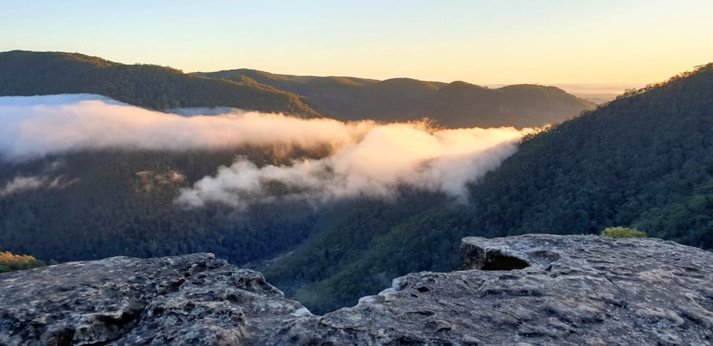 gray rocky mountain with fog during daytime