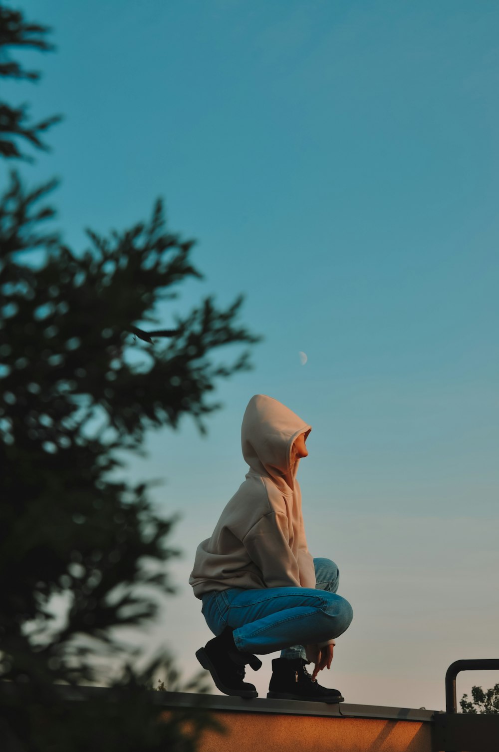 woman in blue denim jacket and blue denim jeans sitting on blue plastic chair under blue