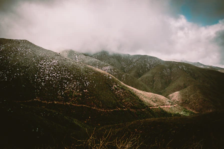 green and black mountains under white clouds during daytime