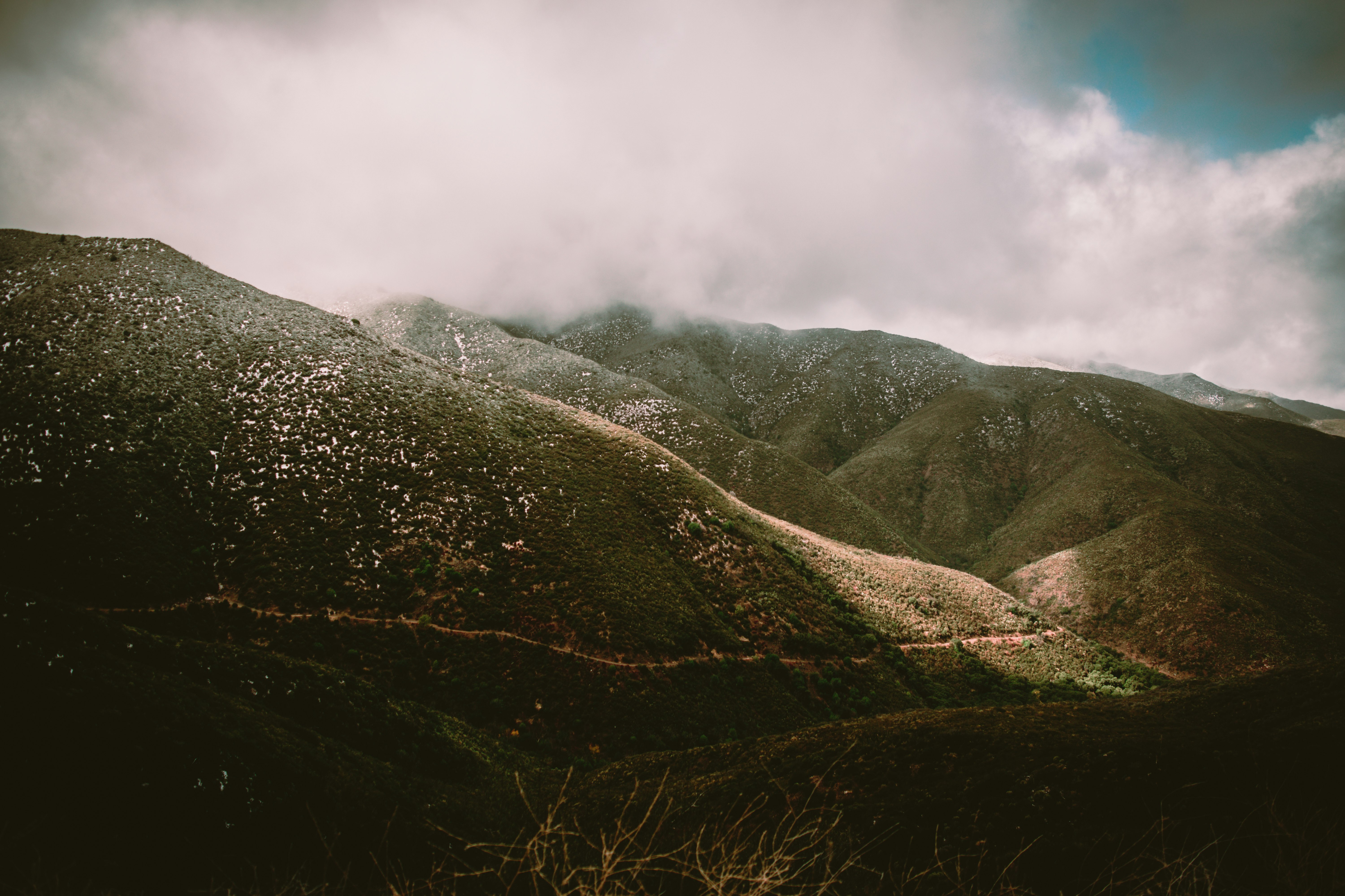 green and black mountains under white clouds during daytime