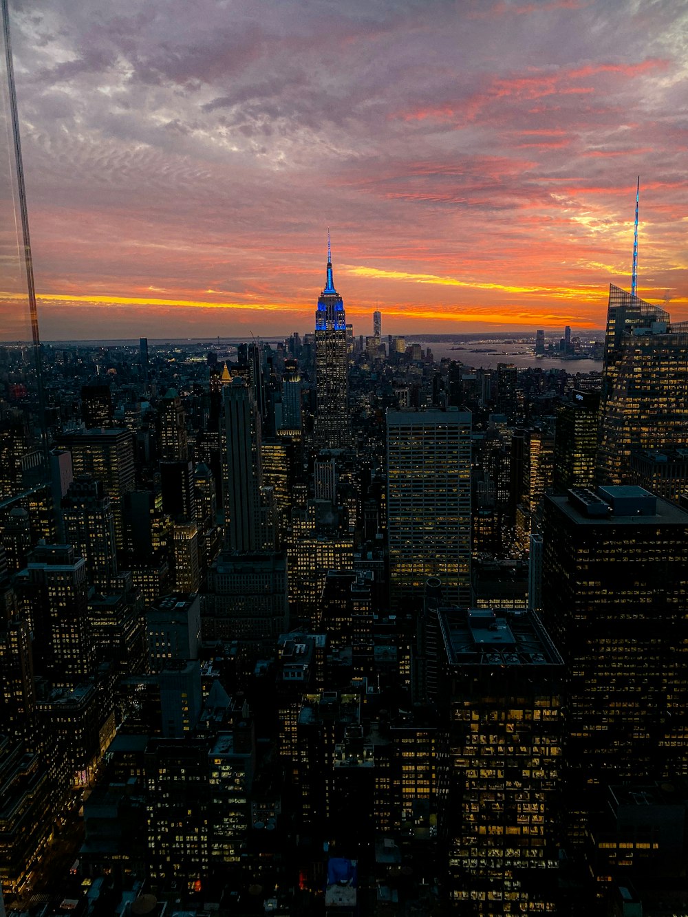 city skyline under orange and blue cloudy sky during sunset