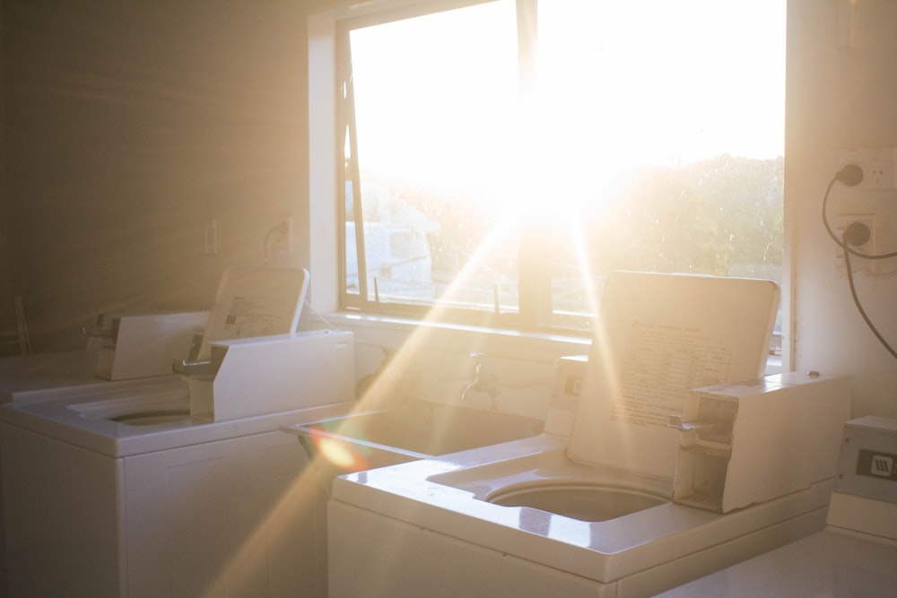 white ceramic bathtub near window