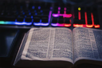 An open digital book displaying multimedia content including video thumbnails and interactive links glowing on the screen.