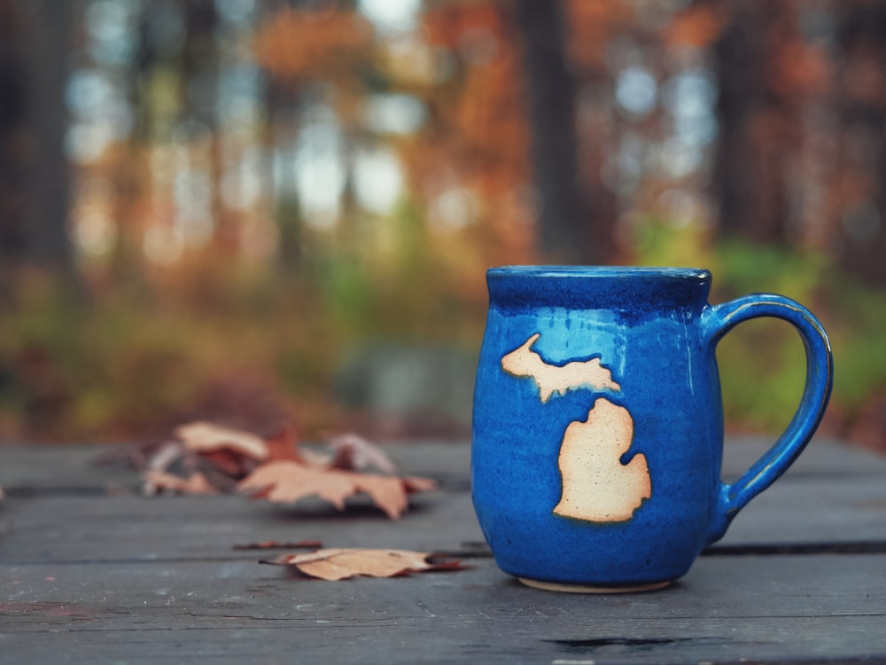 blaue Keramiktasse auf braunem Holztisch