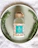 Close-up of a glass bottle of velora balsamic dressing with fresh herbs around it.