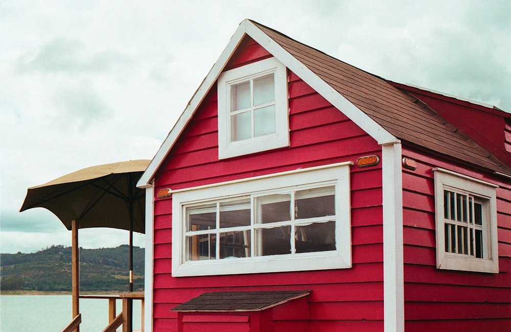 casa di legno rossa e bianca sotto nuvole bianche durante il giorno