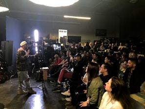 A filmmaker presenting a live webinar with cinematic visuals on screen behind.