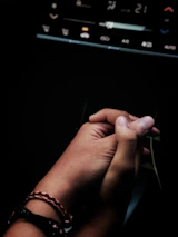 A close-up of hands shaking over a consórcio contract with a car in the background.