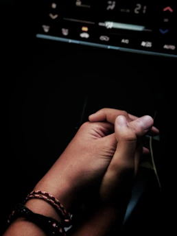 A close-up of hands shaking over a consórcio contract with a car in the background.