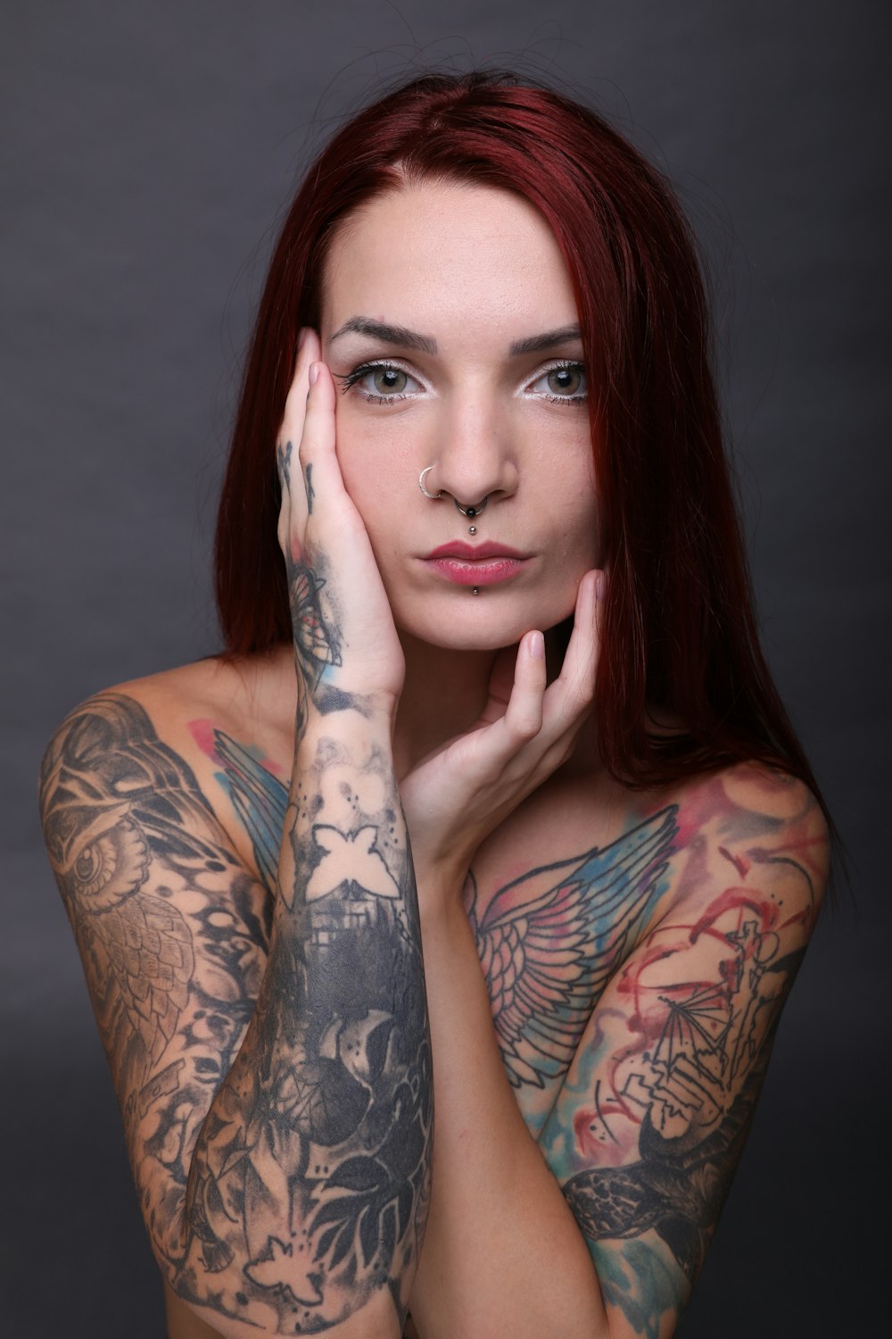 woman with black and red floral tattoo on her left arm